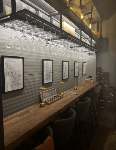 Close-up of Riedel wine glasses placed in elegant wine glass holders in Vinteknikk's showroom, surrounded by WineGuard glass system and warm lighting.