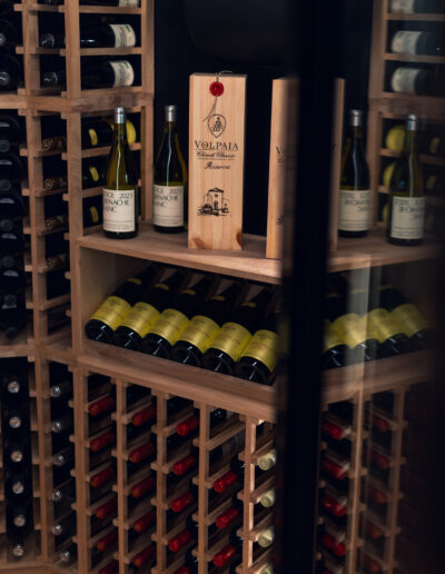 Caverack Alda wine system installed inside wine room from Vinteknikk, with oak shelves, integrated LED lighting and WineGuard glass system in matt black aluminium.