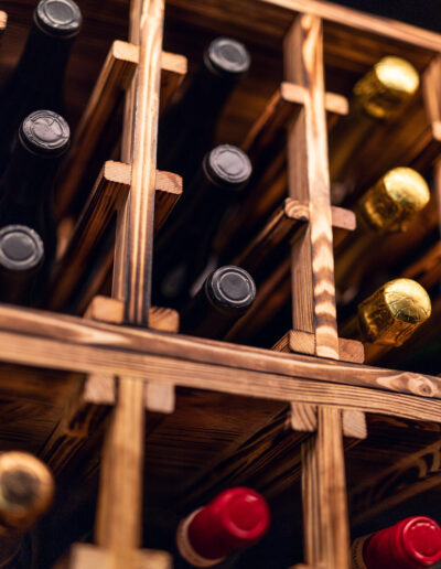 Caverack Half Alda wine shelf in charred pine from Vinteknikk, with warm surface texture and integrated LED lighting that highlights the wine bottles and the material's character.