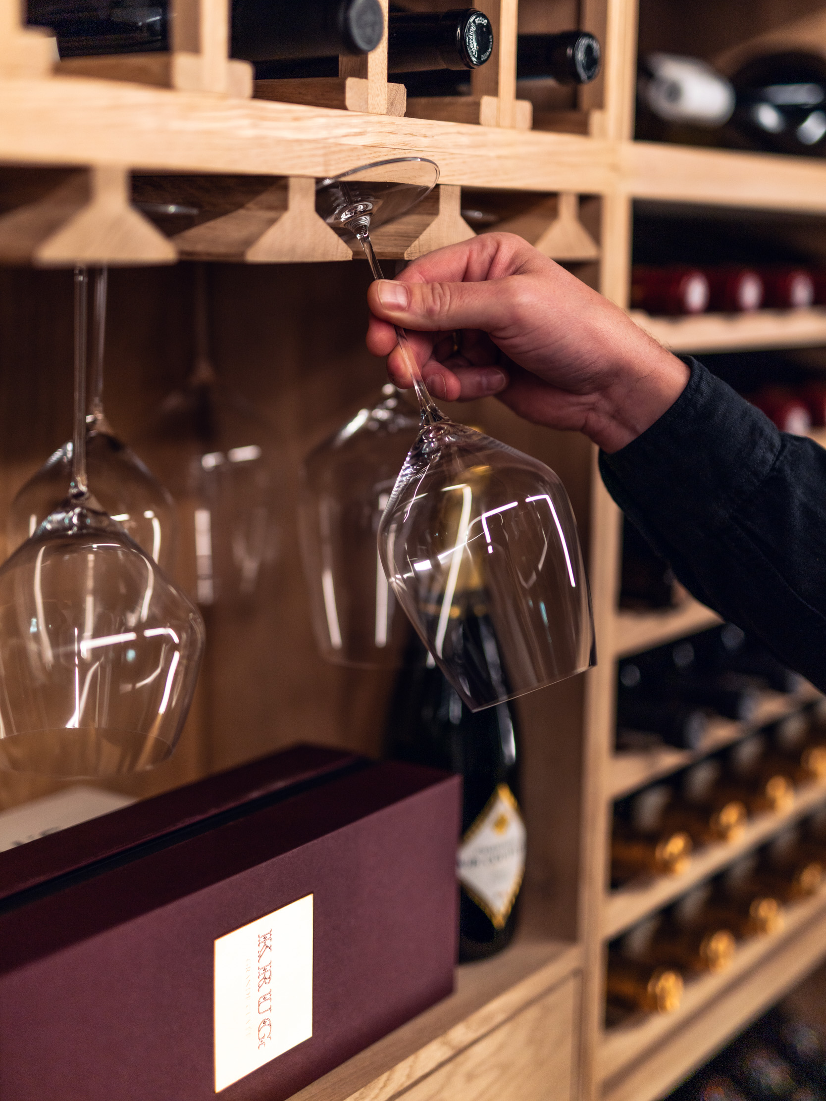 vinkelner som tar ut glass av vinhylle fra vinteknikk