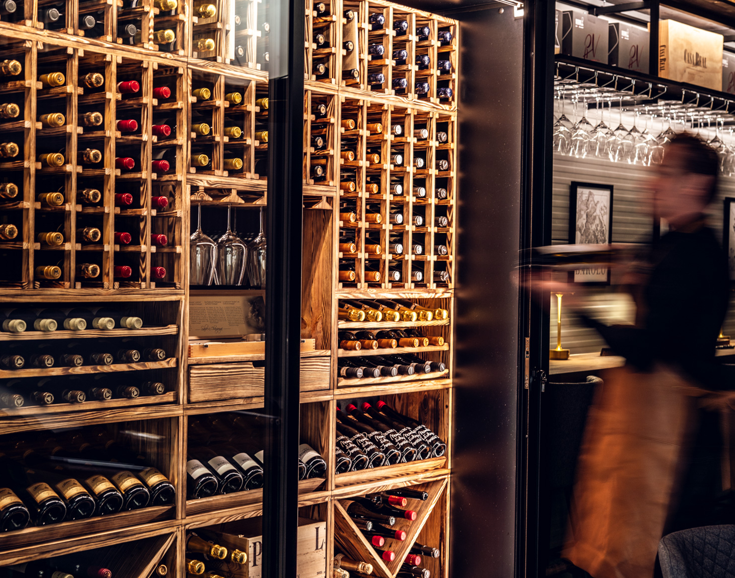 vinkelner som tar ut glass av vinhylle fra vinteknikk